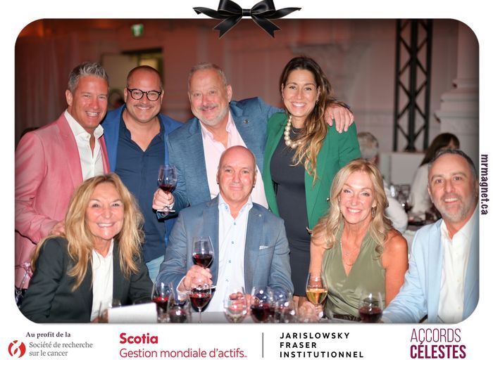 A group of friends with glasses of red wine at the gala