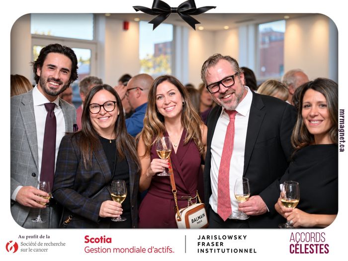 Five guests smiling with glasses of white wine at the reception