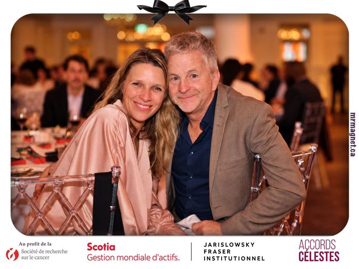 A couple leaning together at their dinner table