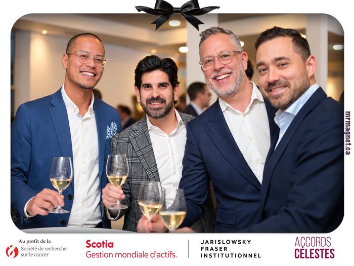 Four friends raising wine glasses at a standing table