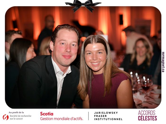 A couple posing at their table in warm orange lighting