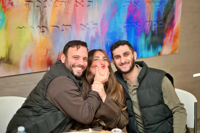 Three friends having fun in front of colourful artwork