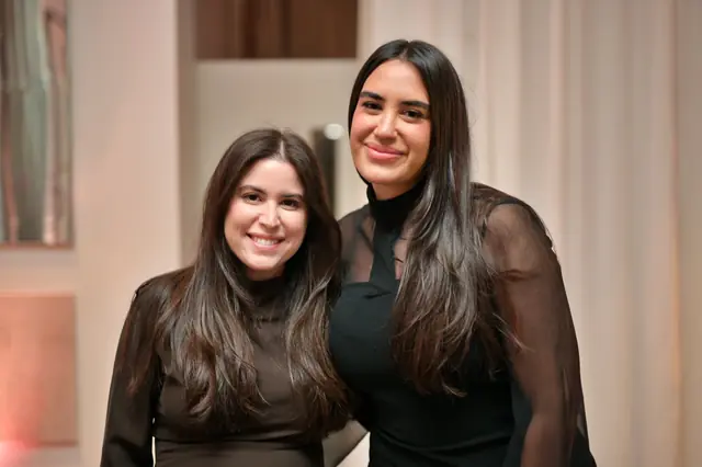 Two women in black at an evening celebration