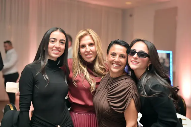 Four friends smiling together at a gala