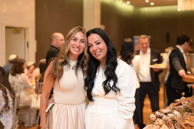 Two friends embracing at a catered reception